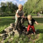 kaksospojat kiipeilee kivillä