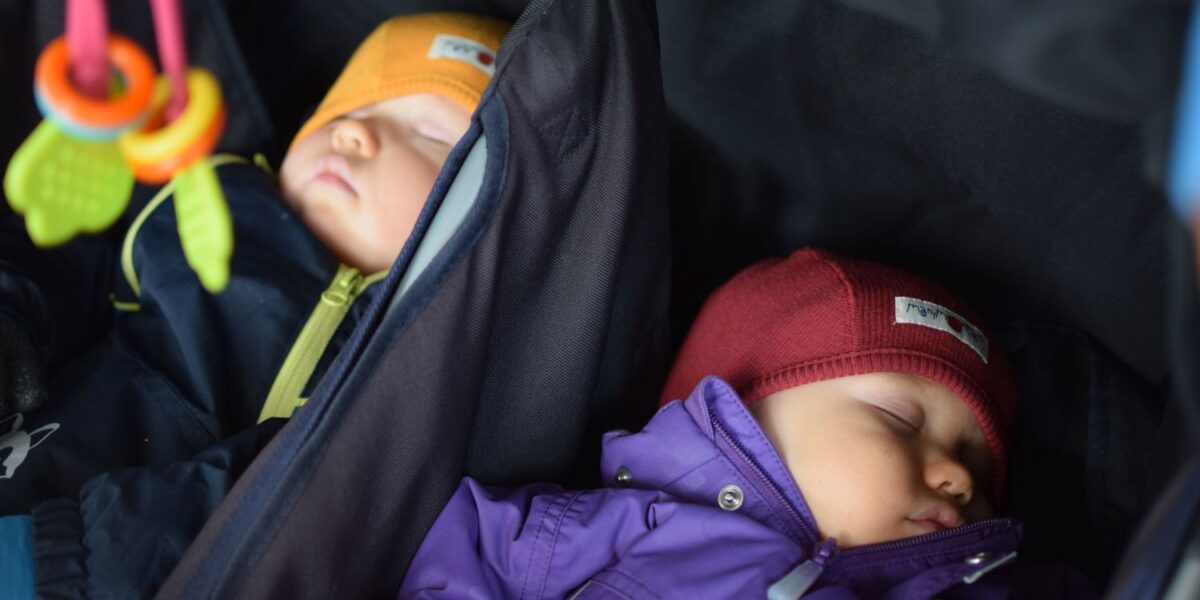 kaksi vauvaa nukkuu ulkovaatteissa lastenvaunuissa