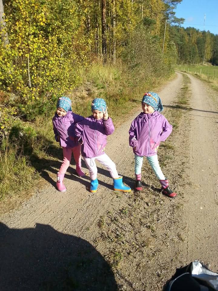 Kolmossisarukset ulkoilemassa hiekkatiellä aurinkoisessa syyssäässä.