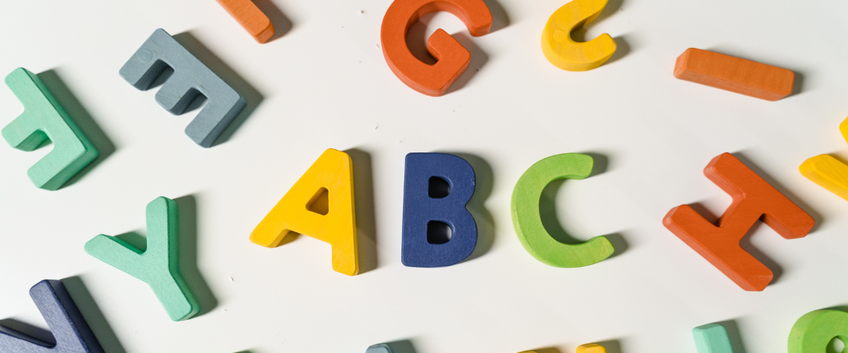 värikkäitä kirjaimia sikin sokin, keskellä A, B ja C.