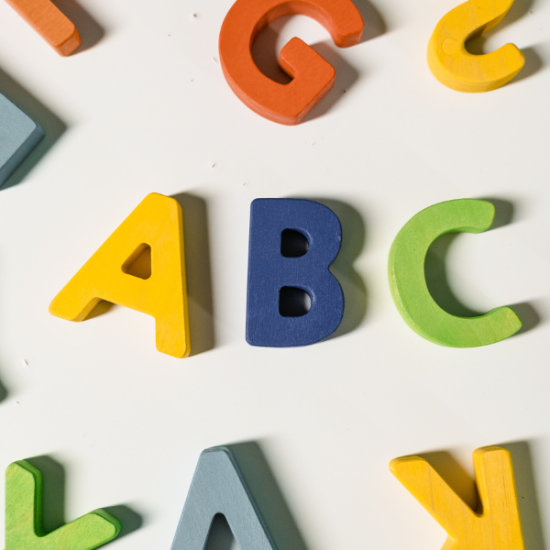 värikkäitä kirjaimia sikin sokin, keskellä A, B ja C.