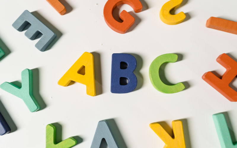 värikkäitä kirjaimia sikin sokin, keskellä A, B ja C.